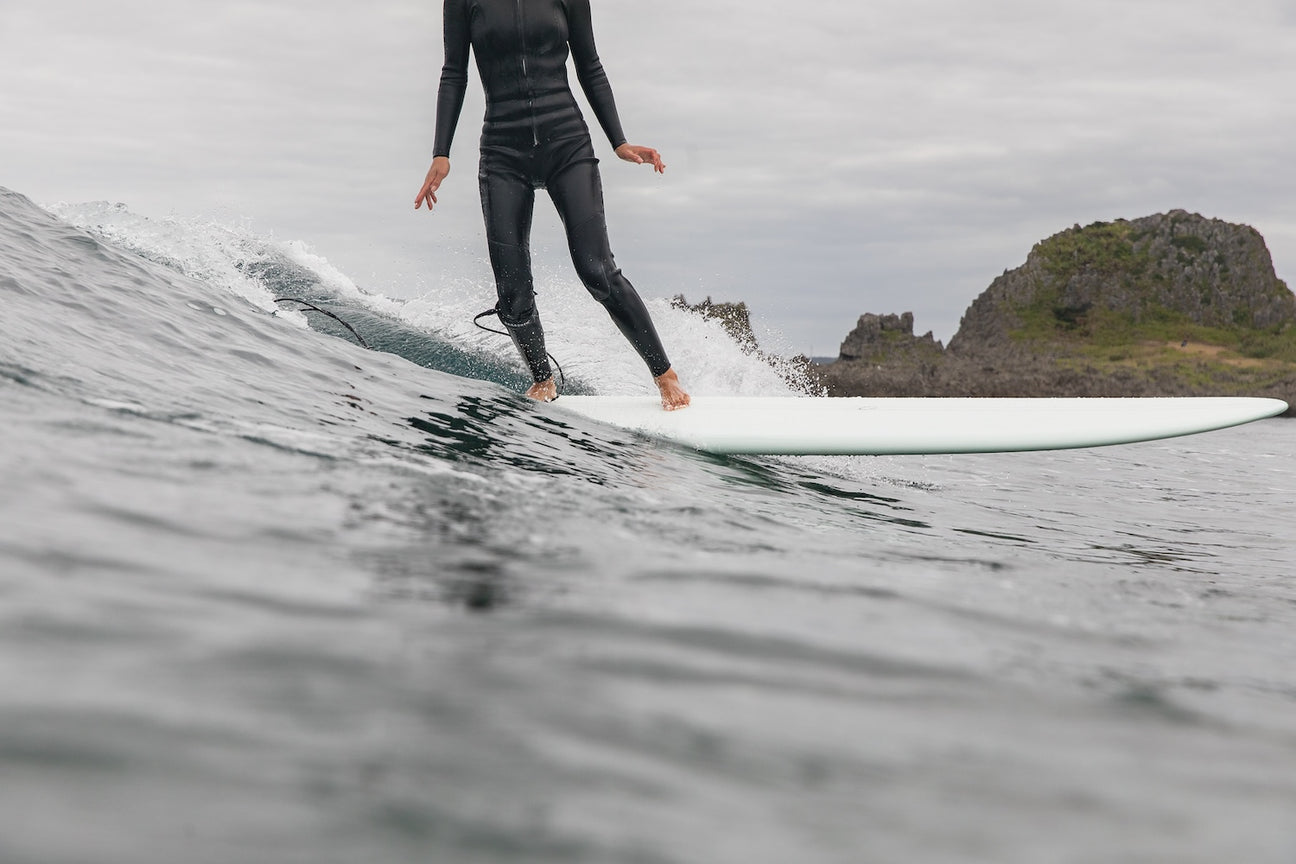 Proper surf leash attachment demonstrated during takeoff