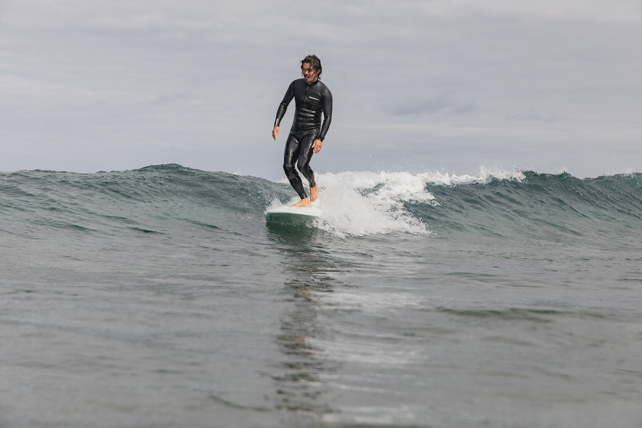 Surfer on a longboard showing fin engagement